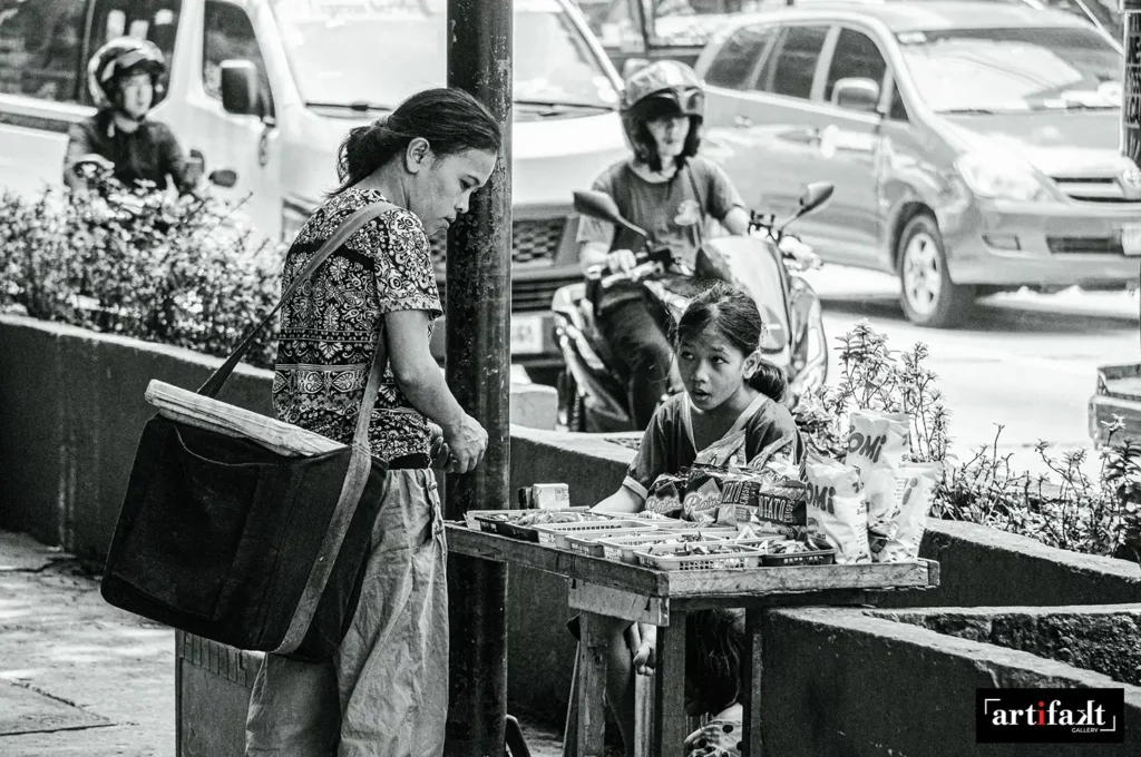A women and a child selling in Manila Street along the sidewalk near the national highway